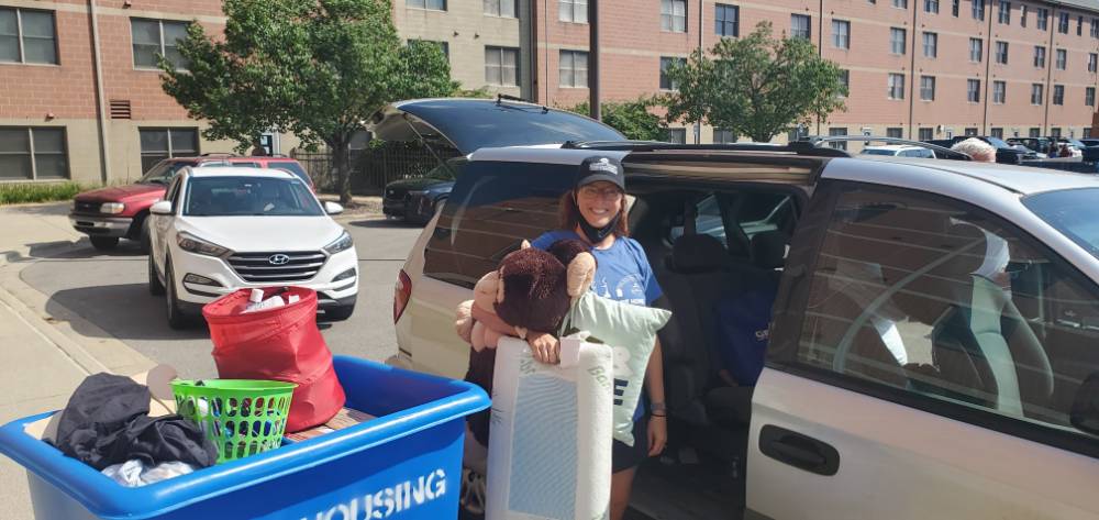 Sara Maas helps a student unload their belongings